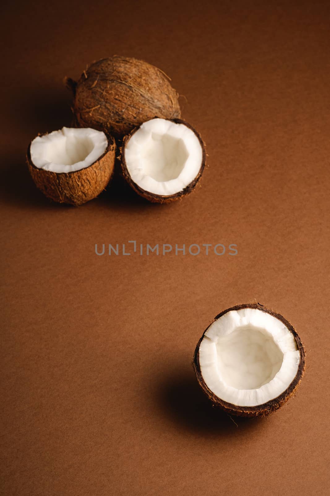 Coconut fruits on brown plain background, abstract food tropical by Frostroomhead