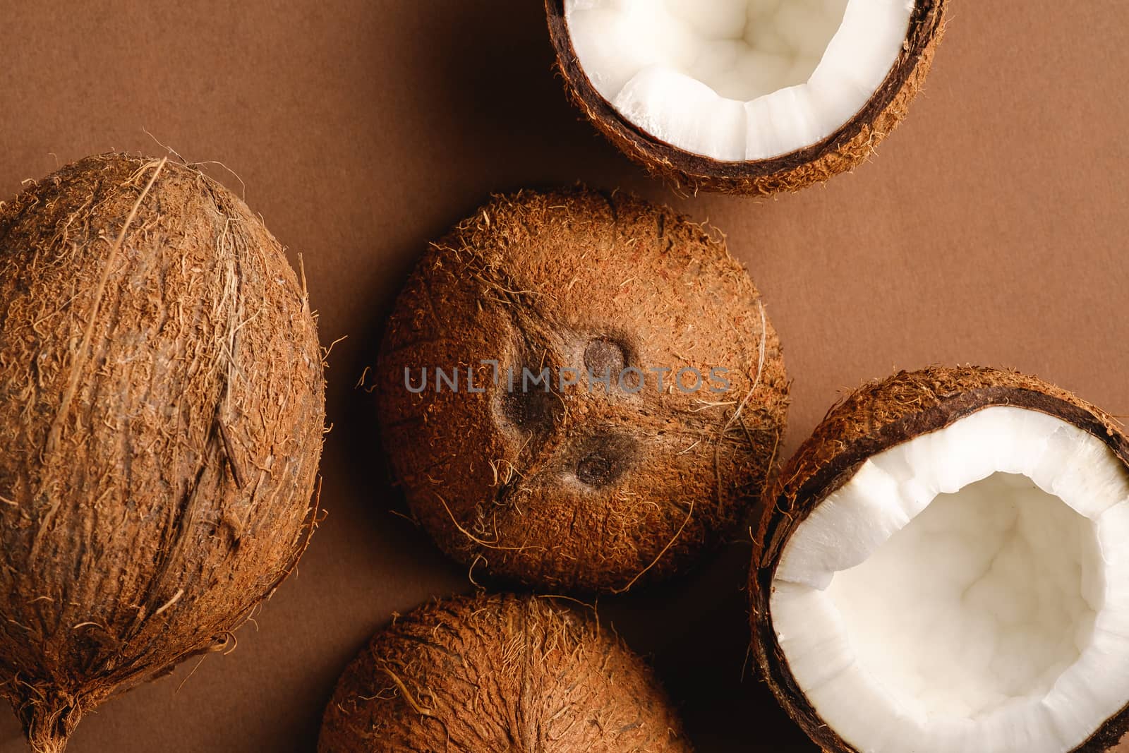Coconut fruits on brown plain background, abstract food tropical by Frostroomhead
