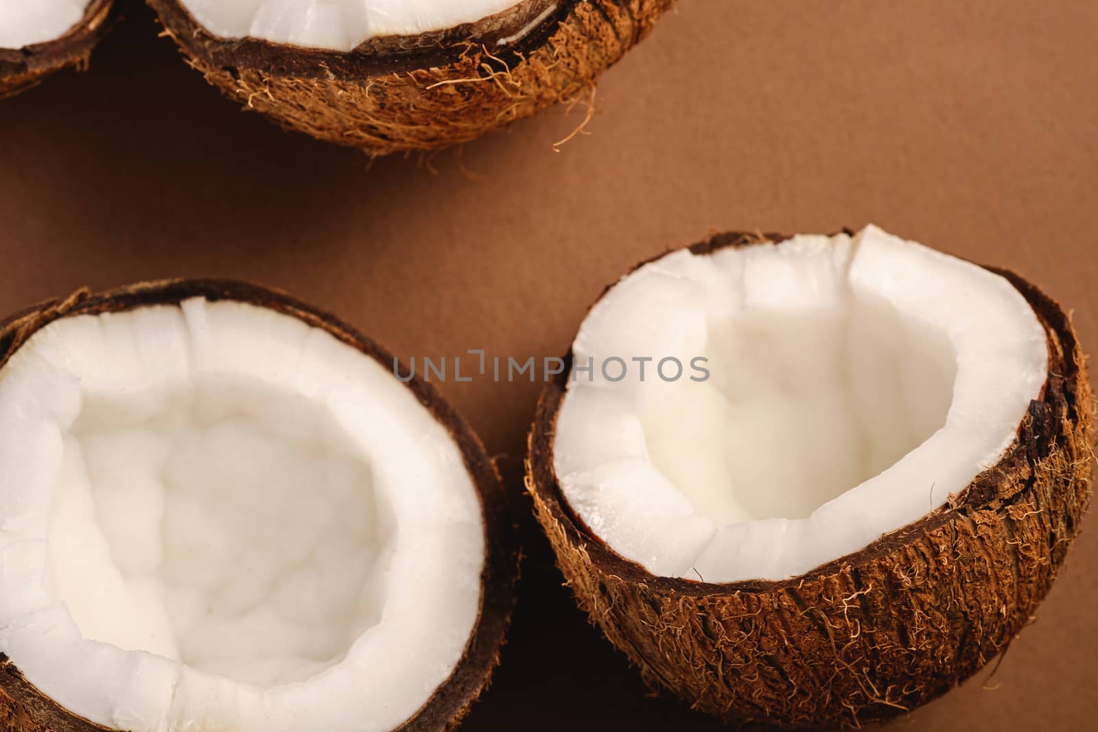 Coconut fruits on brown plain background, abstract food tropical concept, angle view macro