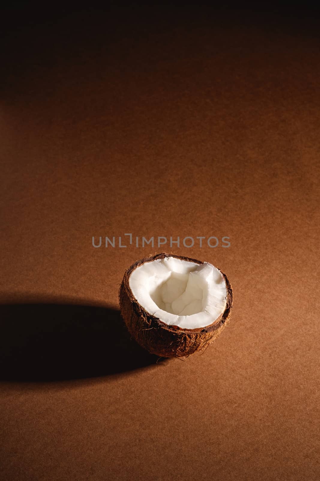 Single coconut fruit on brown plain background by Frostroomhead
