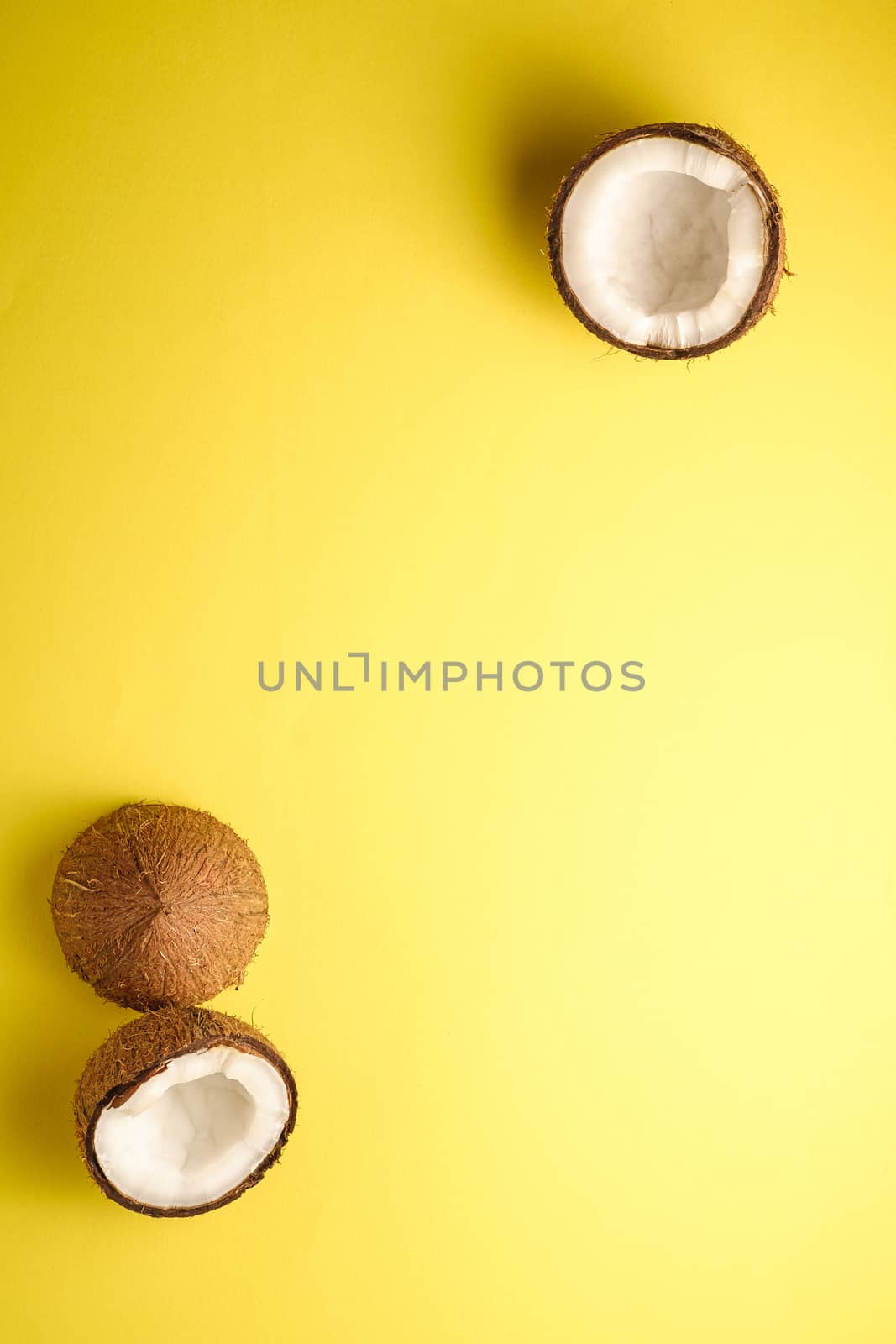 Coconut fruits on yellow plain background, abstract food tropical concept, top view copy space