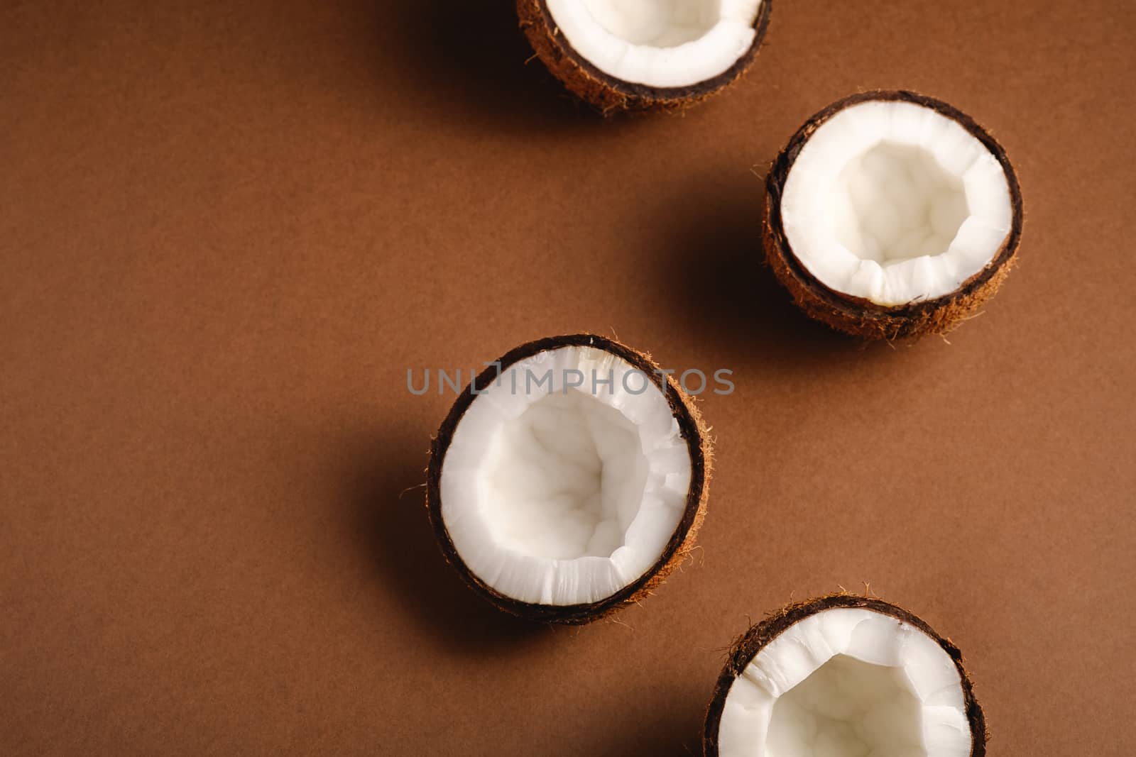 Coconut fruits on brown plain background, abstract food tropical concept, angle view copy space