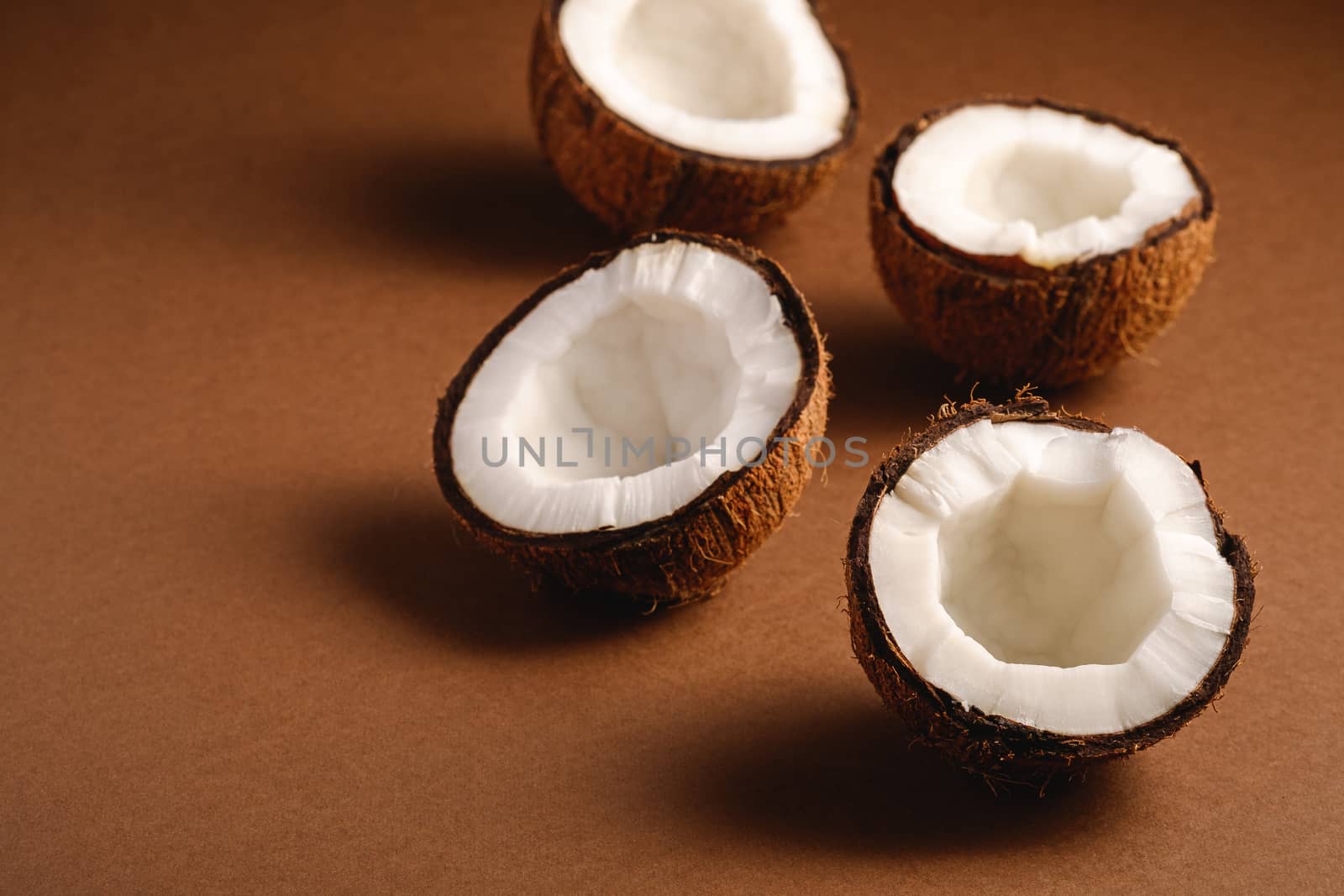 Coconut fruits on brown plain background, abstract food tropical concept, angle view copy space