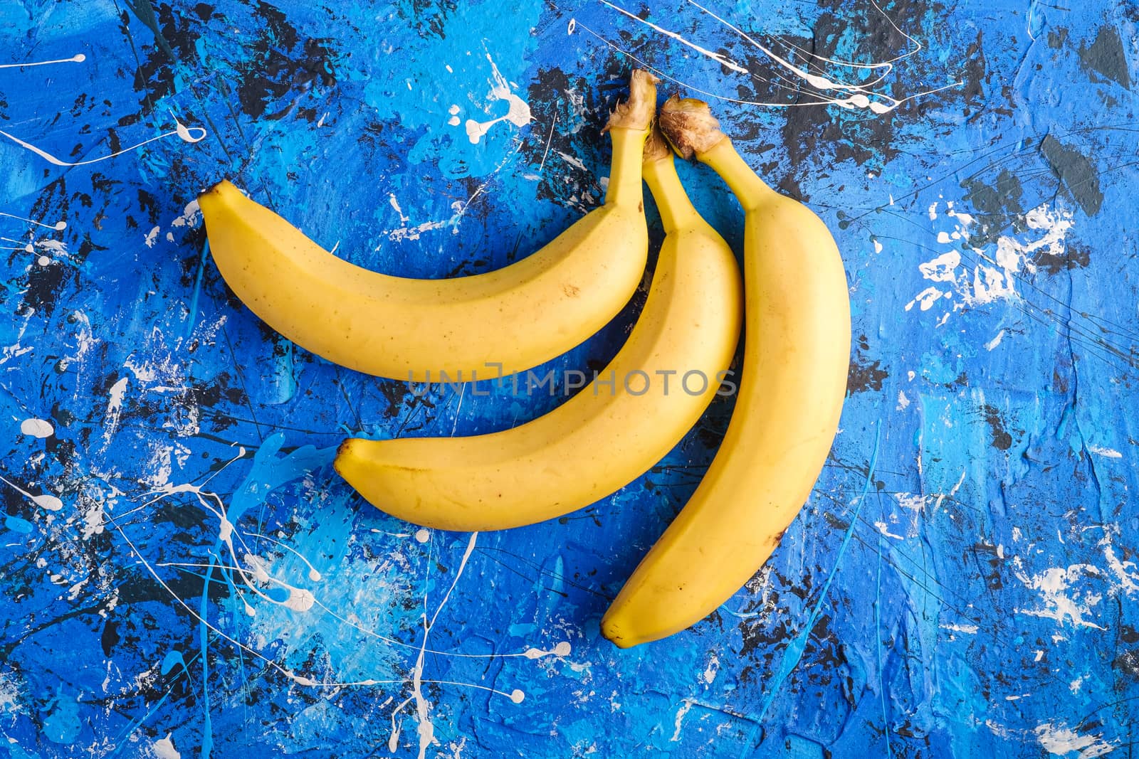 Banana fruits on blue textured background, top view