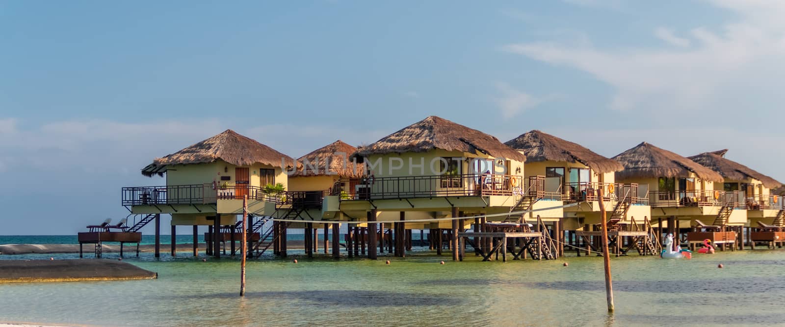 Water Villas (Bungalows) and wooden bridge at Tropical beach in the Caribbean sea at summer day