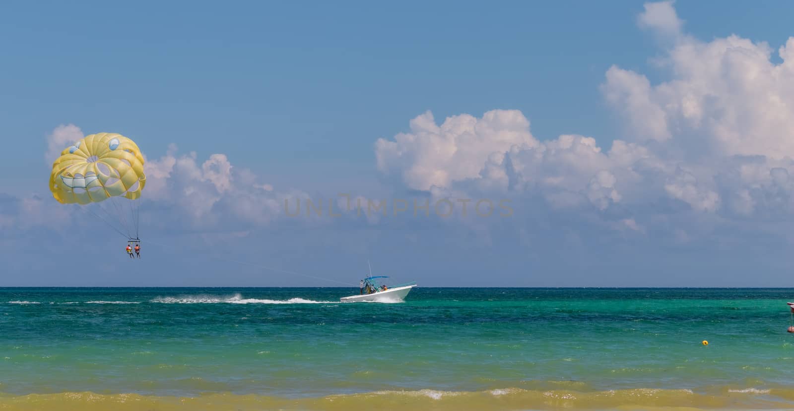 Yellow wing with happy face from skydiving pulled by a boat. Summer by leo_de_la_garza