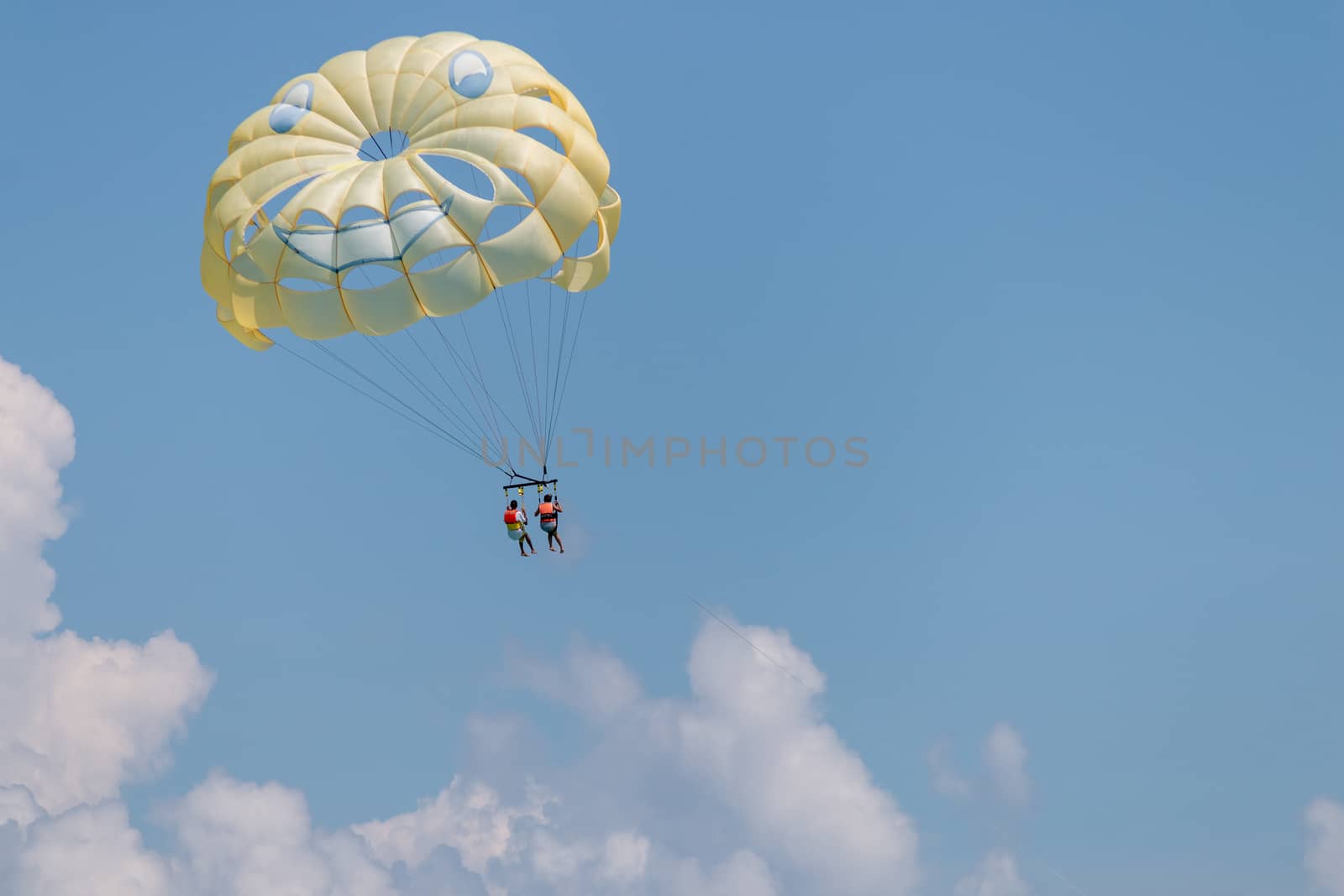 Yellow wing with happy face from skydiving pulled by a boat. Summer by leo_de_la_garza