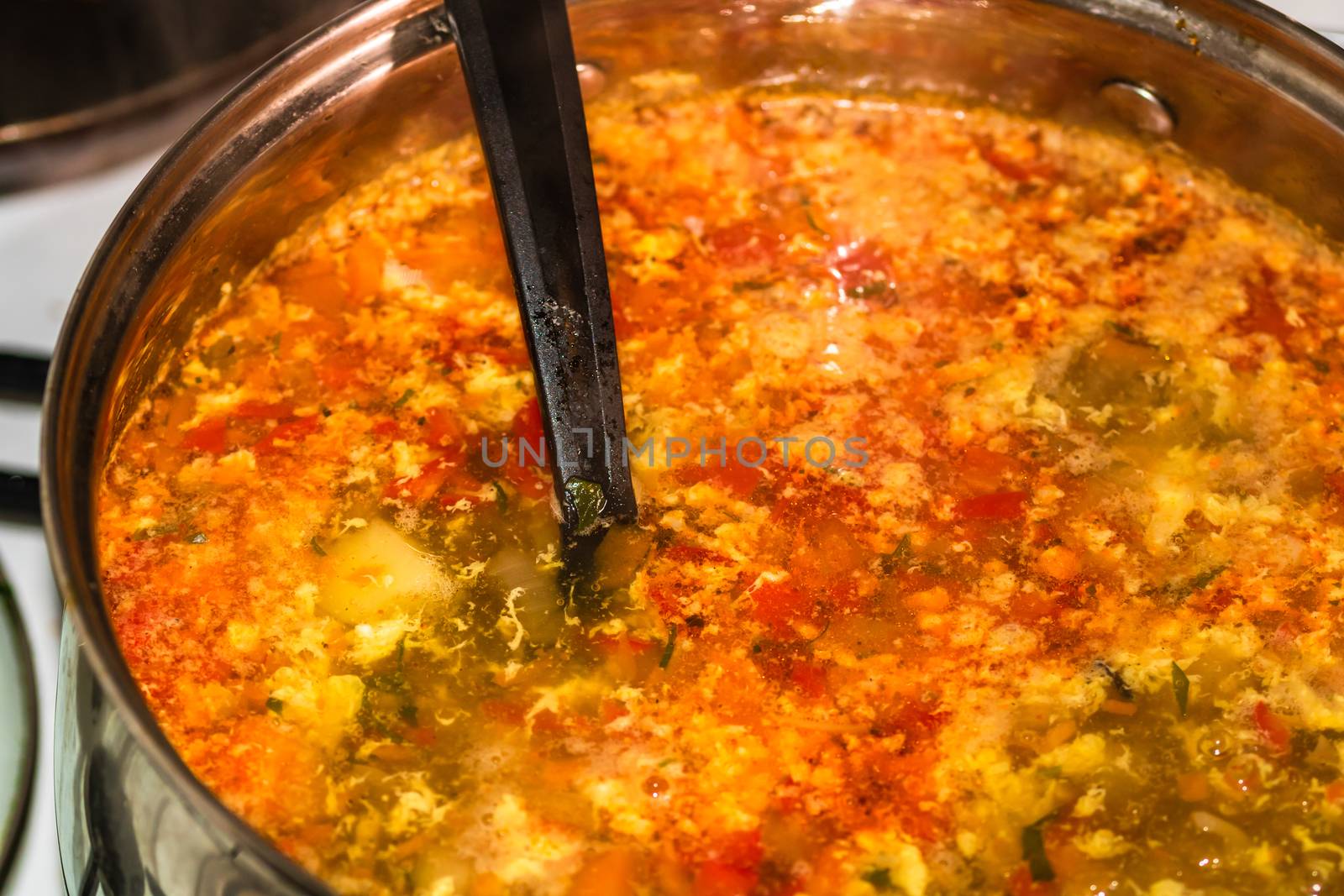 Preparation of soup with chicken and vegetables. Close up of boiling soup.