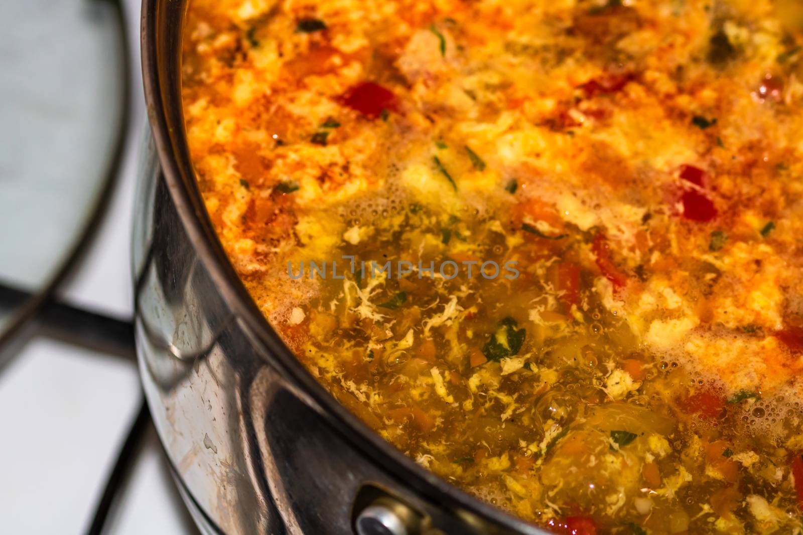 Preparation of soup with chicken and vegetables. Close up of boiling soup.