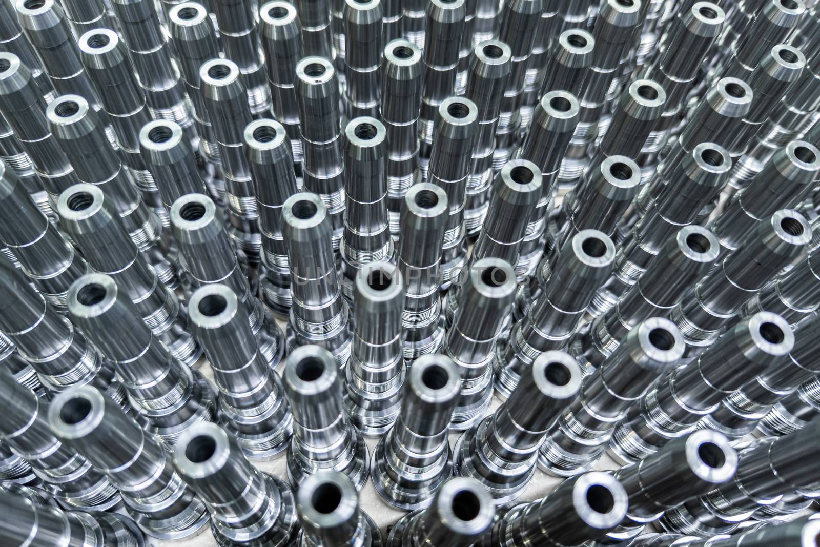 Shiny long steel parts full frame background, clean steel threaded rods after fine cnc turning.