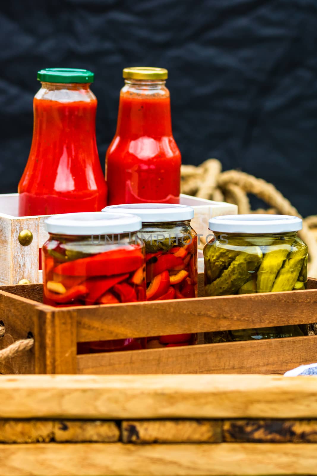 Bottles of tomato sauce, preserved canned pickled food concept isolated in a rustic composition.