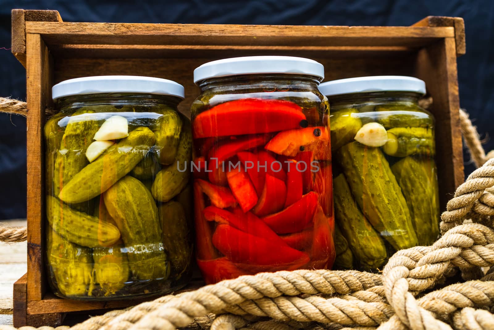 Glass jars with pickled red bell peppers and pickled cucumbers ( by vladispas