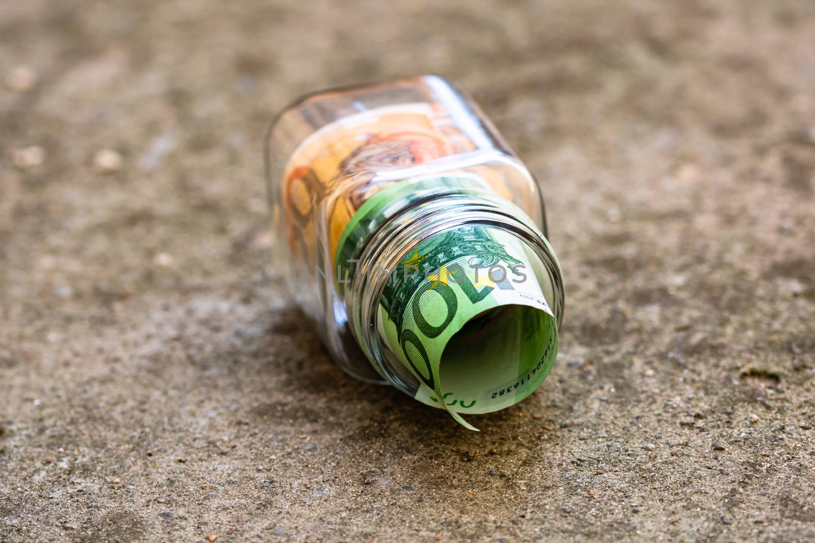 Composition with saving money banknotes in a glass jar. Concept of investing and keeping money, close up isolated.