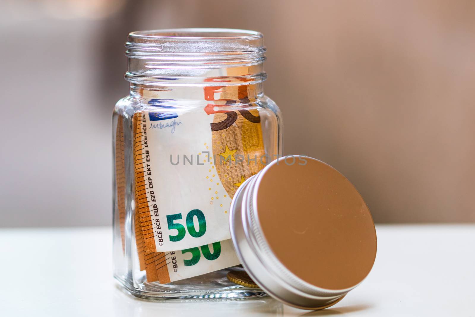 Composition with saving money banknotes in a glass jar. Concept of investing and keeping money, close up isolated.