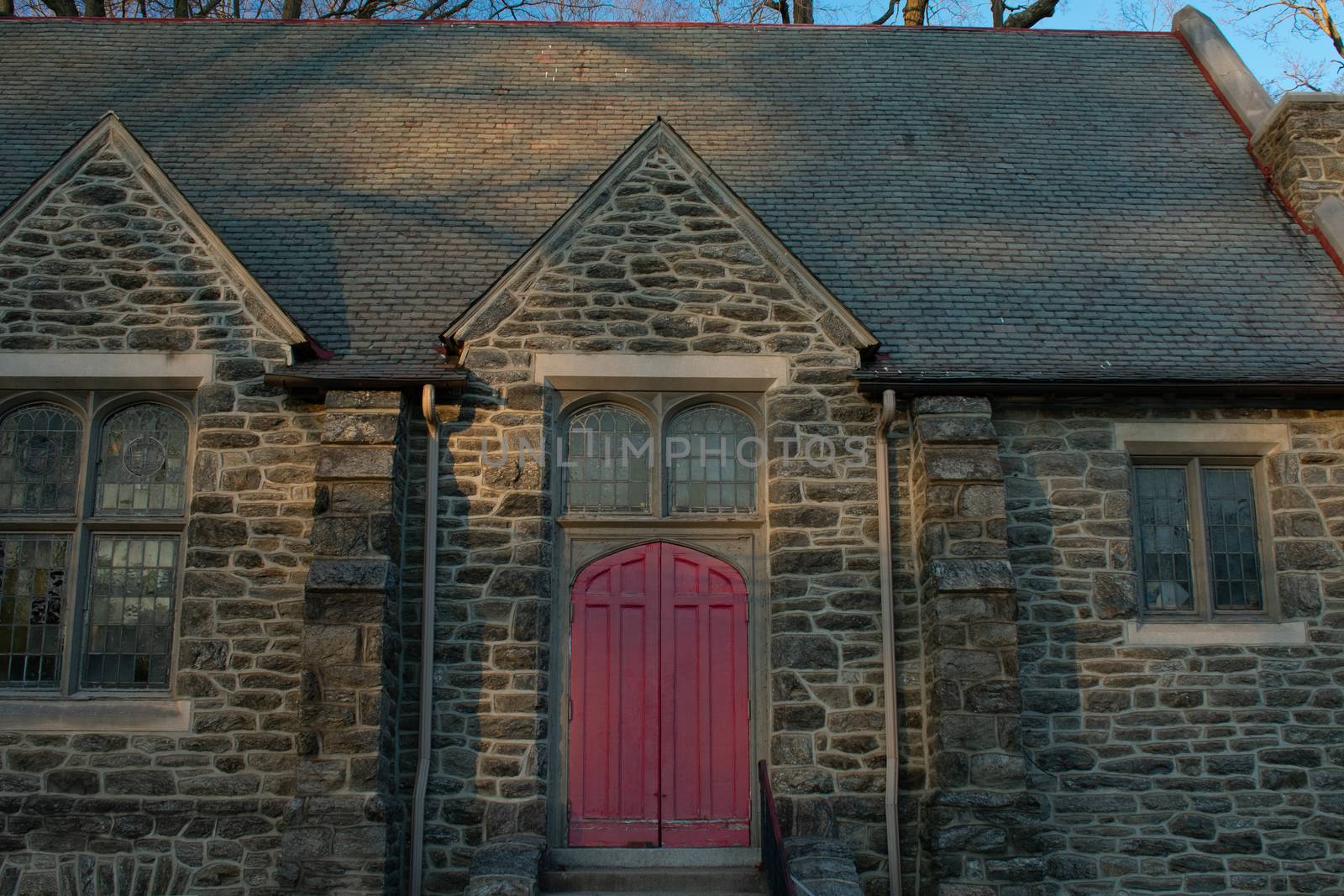 A Bright Red Door in a Cobblestone Church With Steps Leading Up  by bju12290