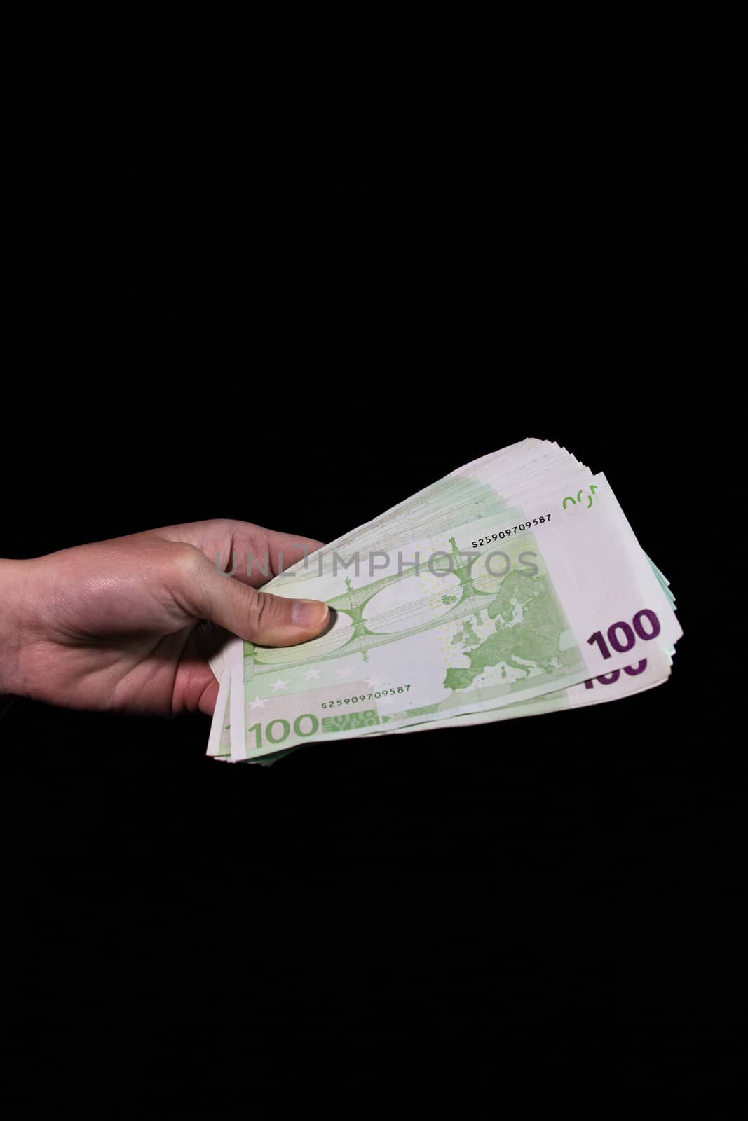 Hand counting holding and showing euro money or giving money. World money concept, 100 EURO banknotes EUR currency isolated on black with copy space. Concept of rich people, saving or spending money