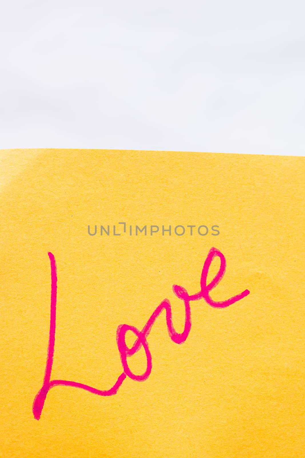 Love handwriting text close up isolated on orange paper with copy space. Writing text on memo post reminder.