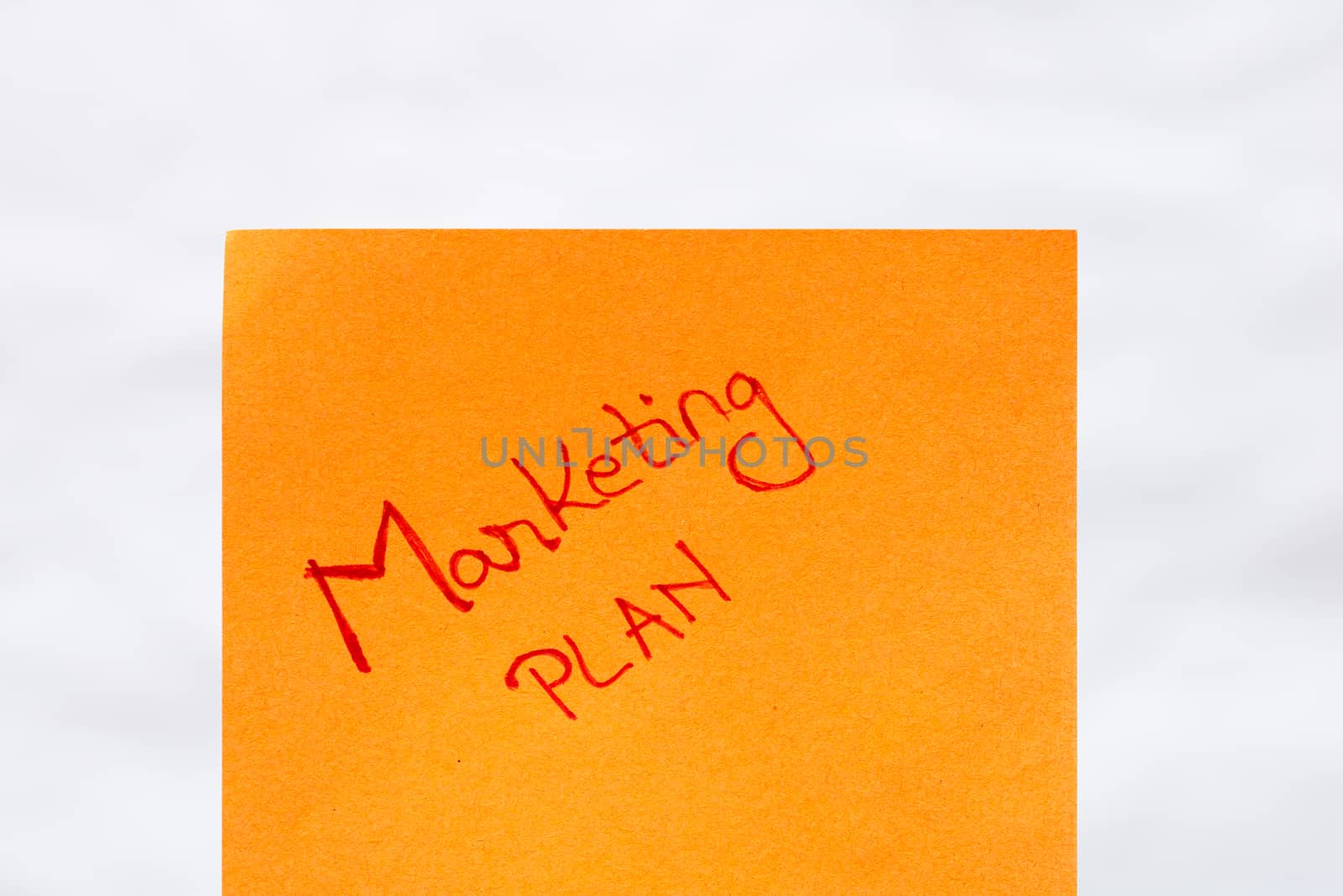 Marketing plan handwriting text close up isolated on yellow paper with copy space.