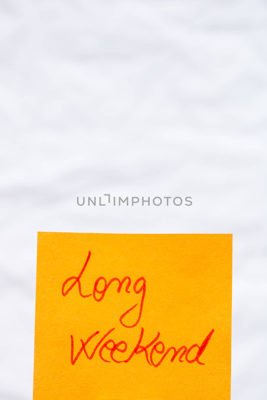 Long weekend handwriting text close up isolated on orange paper with copy space.