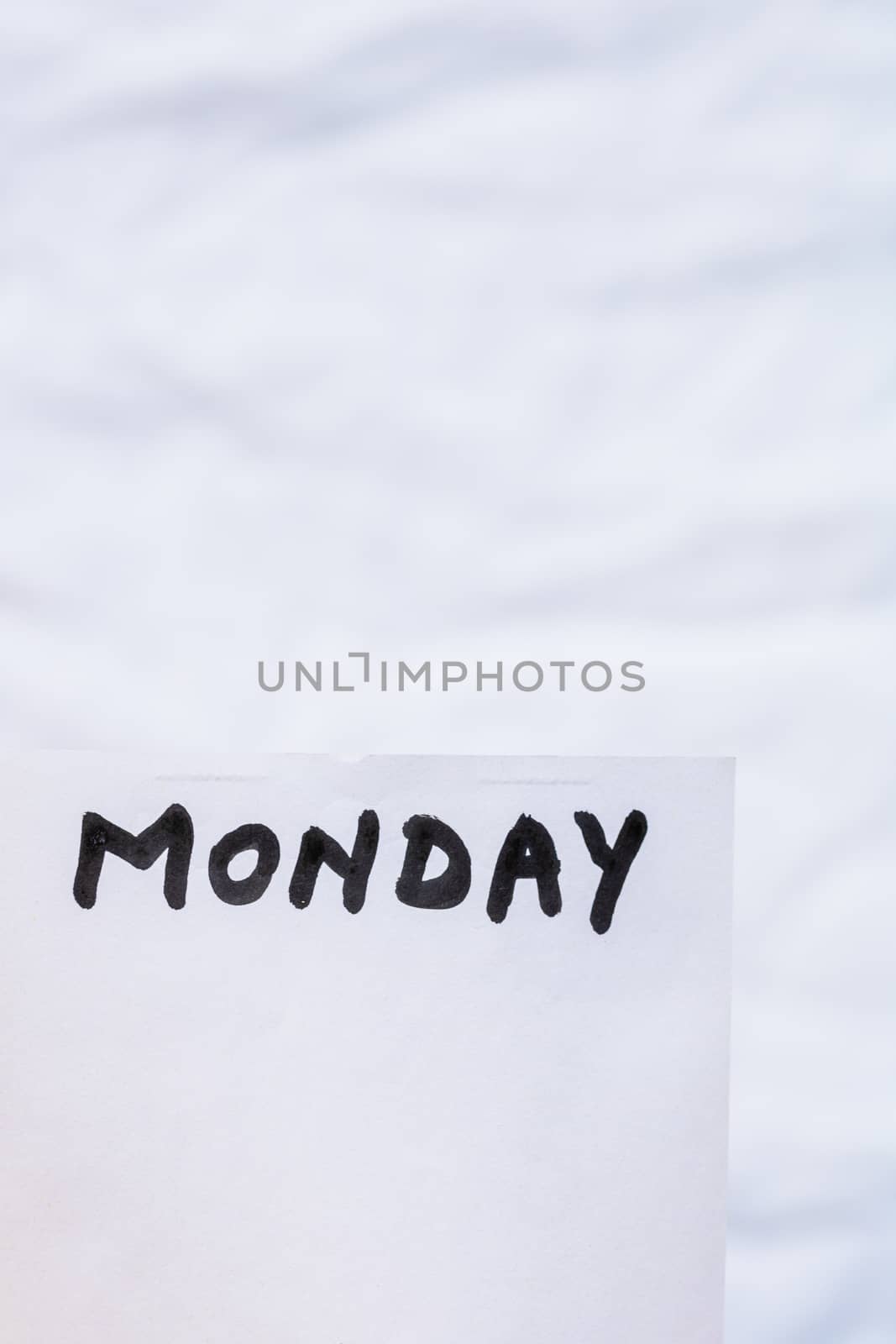 Monday handwriting text close up isolated on white paper with copy space. Writing text on memo post reminder