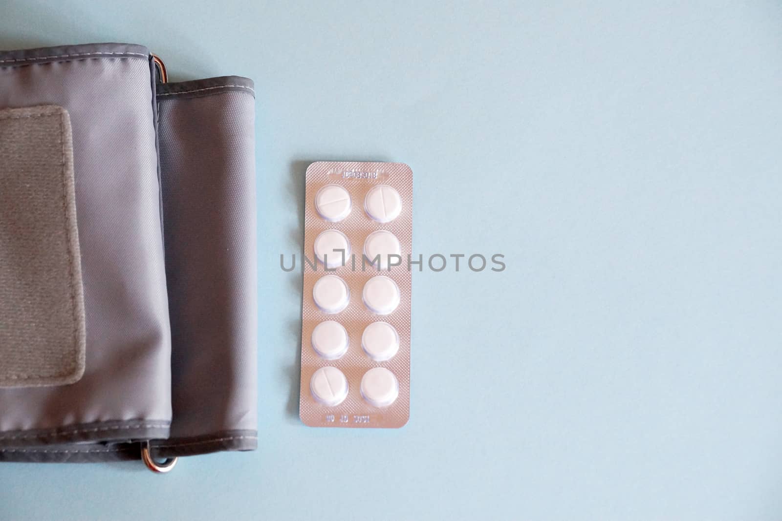 tonometer and pills on blue background, view from above by Annado