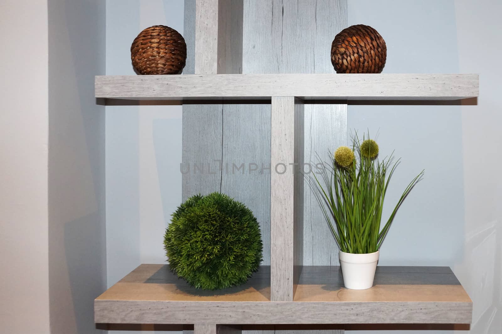 white interior shelf with decorative balls and potted plants.