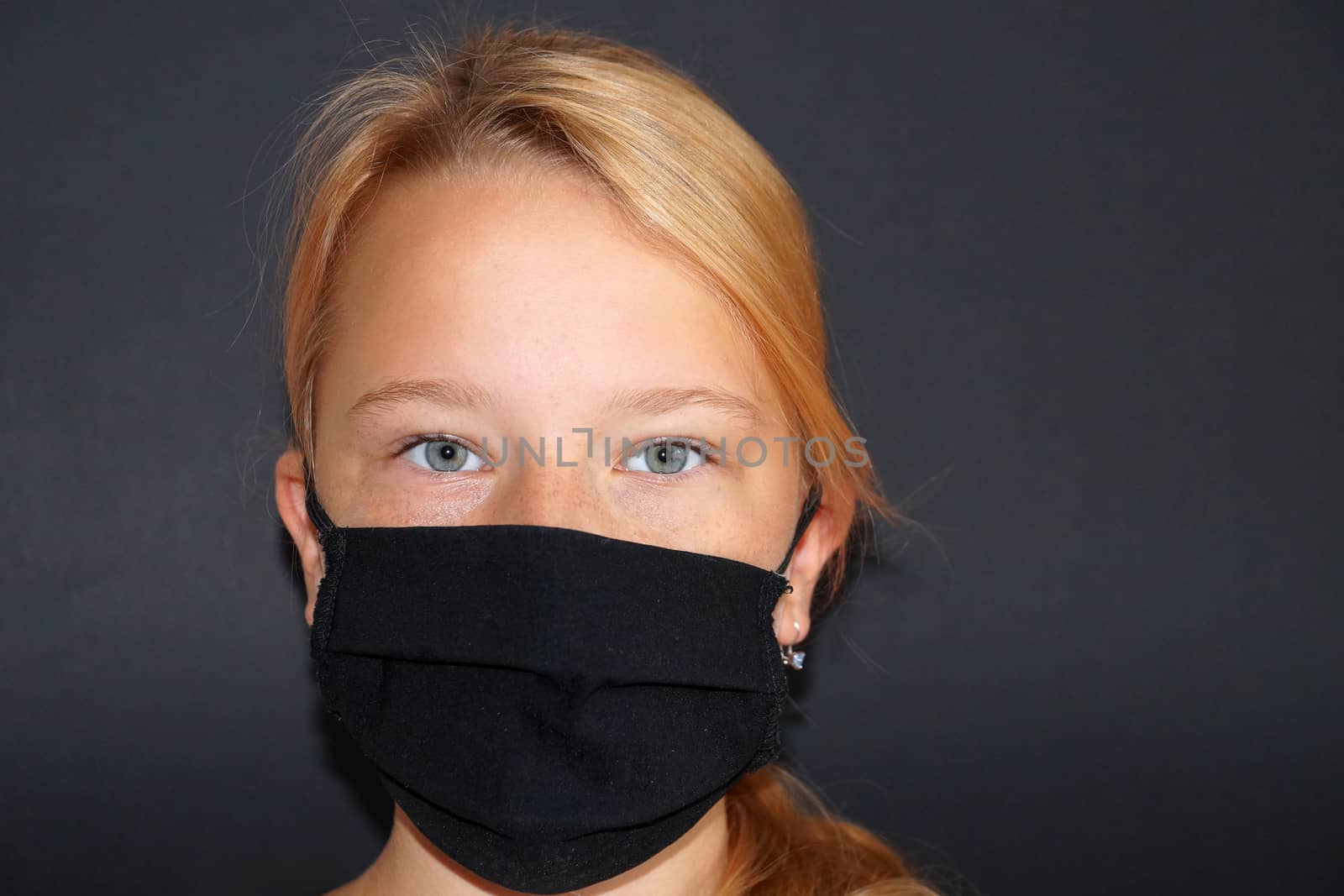 teenage girl in a black medical mask on a black background by Annado