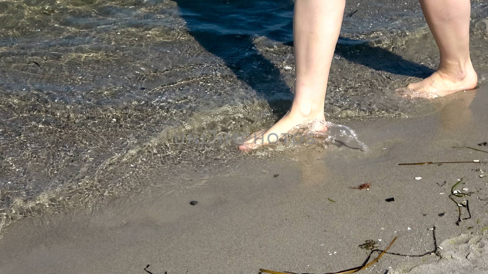 Young female feet walking in the shallow water at a baltic sea b by MP_foto71