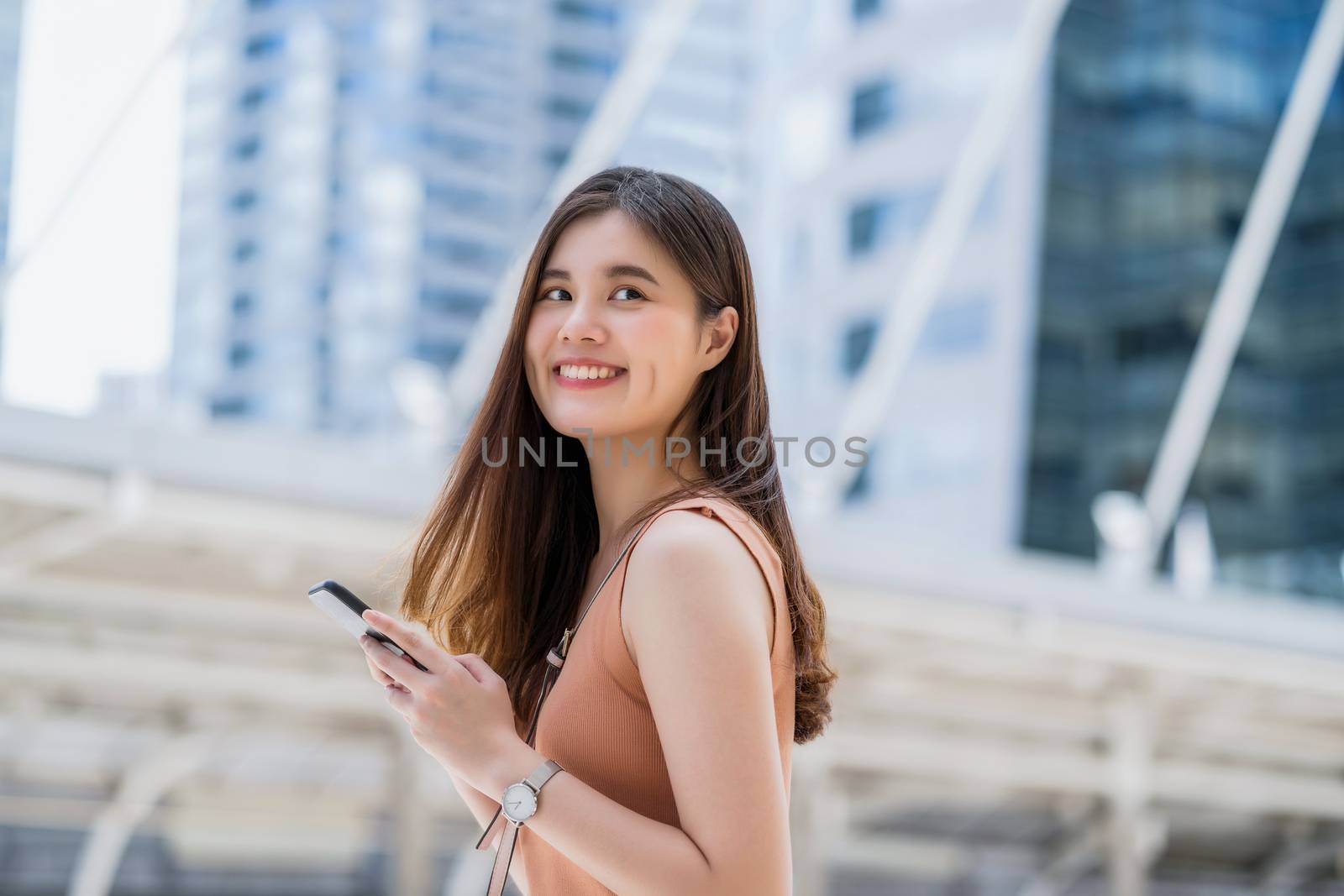 Young Asian woman using smart mobile phone in outside big city at Covid19 outbreak, Infection and Pandemic, commuter and transportation, social distancing and new normal concept