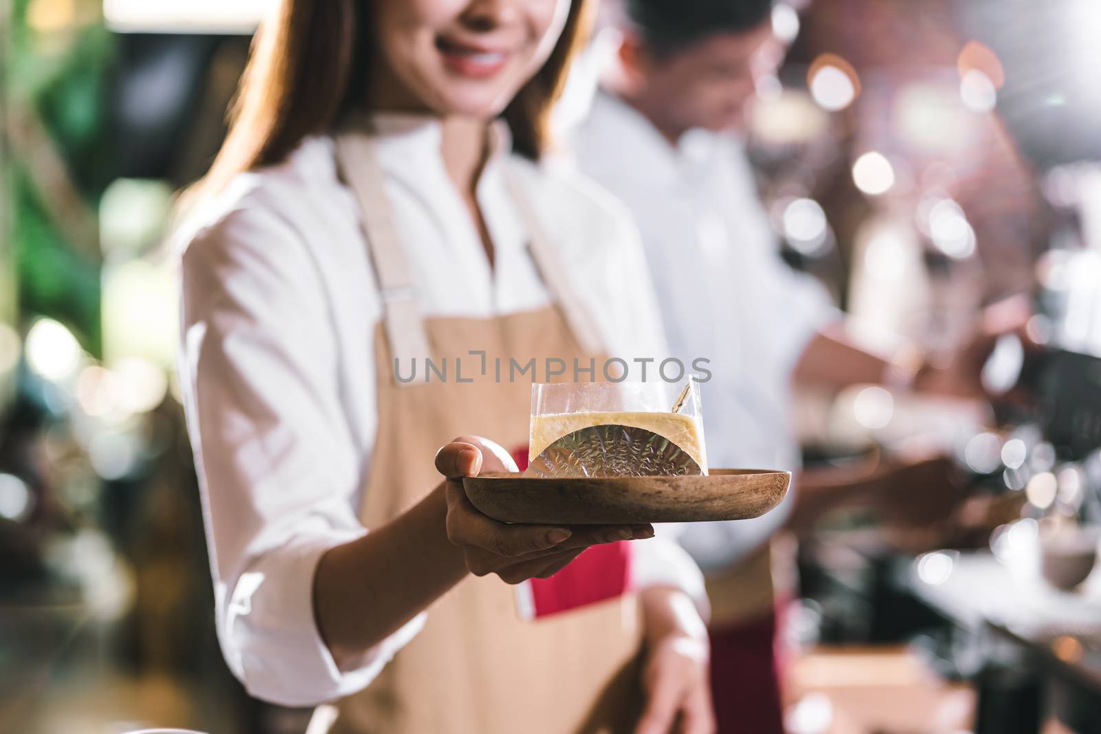 Asian Barista serving a paper cup of coffee to customer in coffee shop, Small business owner and startup in coffee shop and restaurant concept