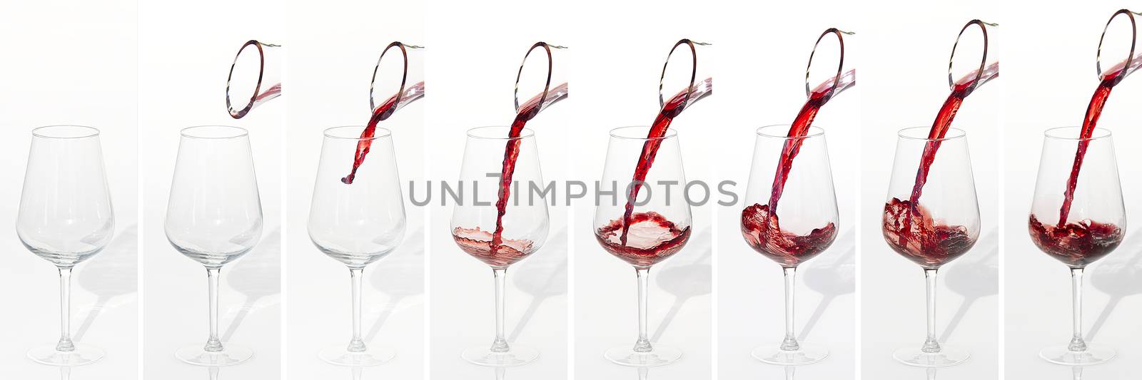 Sommelier pours red wine from decanter to wineglass on white bac by PhotoTime