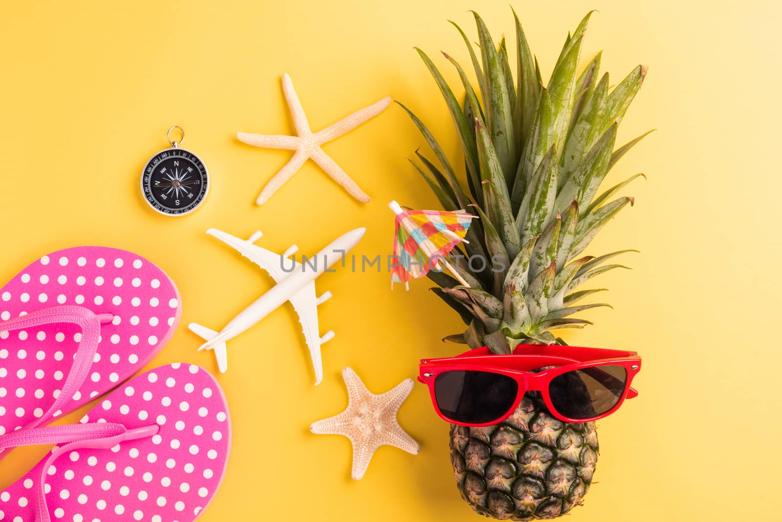 Celebrate Summer Pineapple Day Concept, Top view flat lay of funny fresh pineapple in sunglasses with model plane and starfish, in studio isolated on yellow background, Holiday summertime in tropical