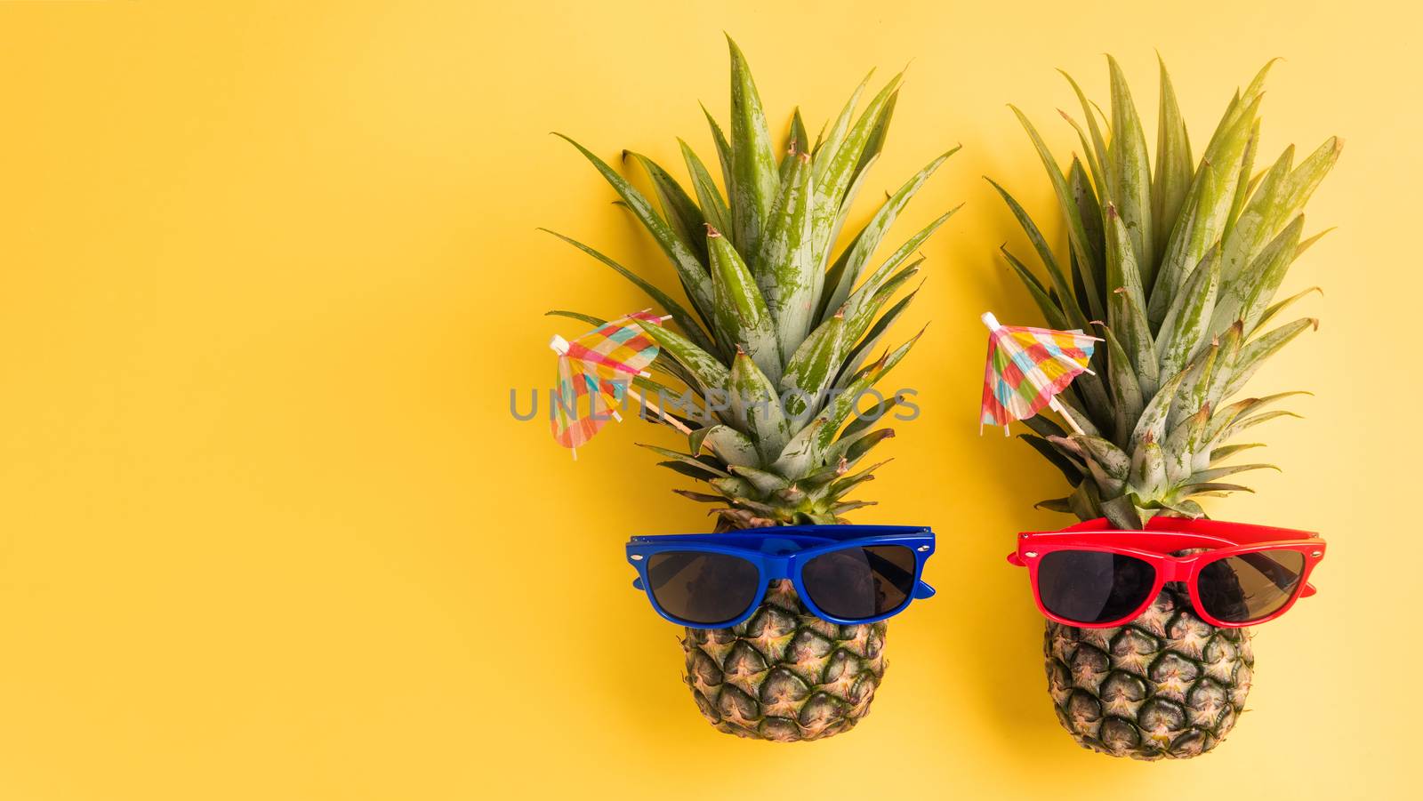 Celebrate Summer Pineapple Day Concept, Top view flat lay of funny two pineapples in sunglasses, studio shot isolated on yellow background, Holiday summertime in tropical