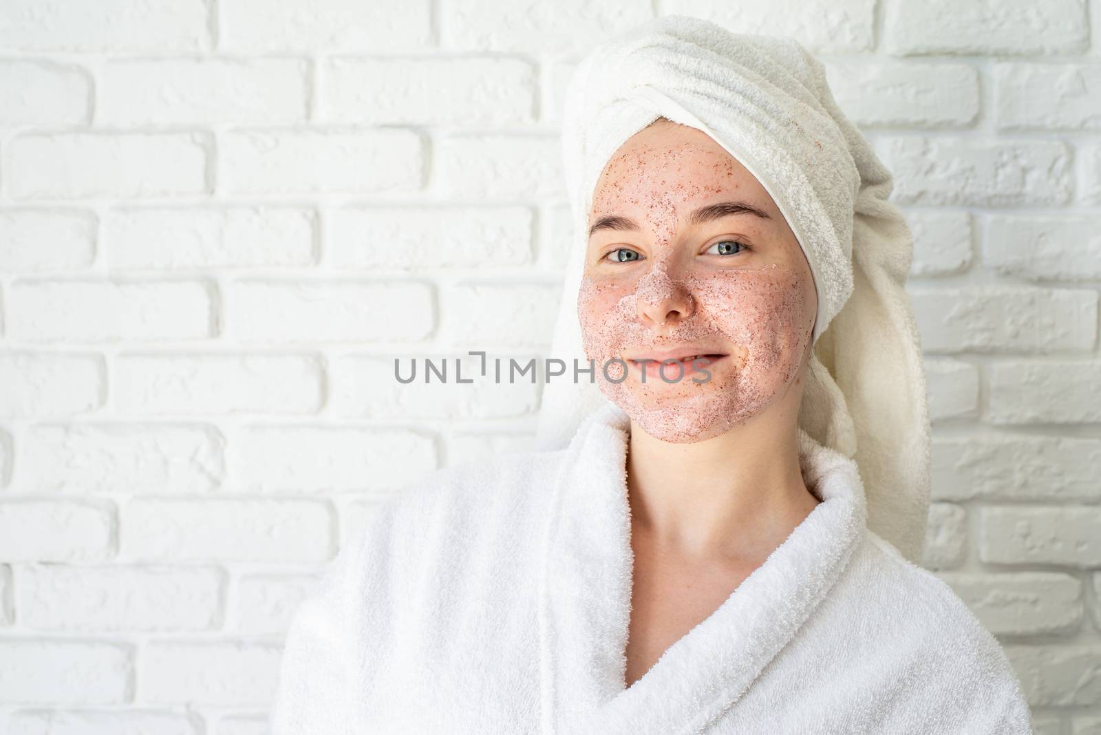 Spa and wellness. Natural cosmetics. Self care. Happy young woman applying face scrub on her face