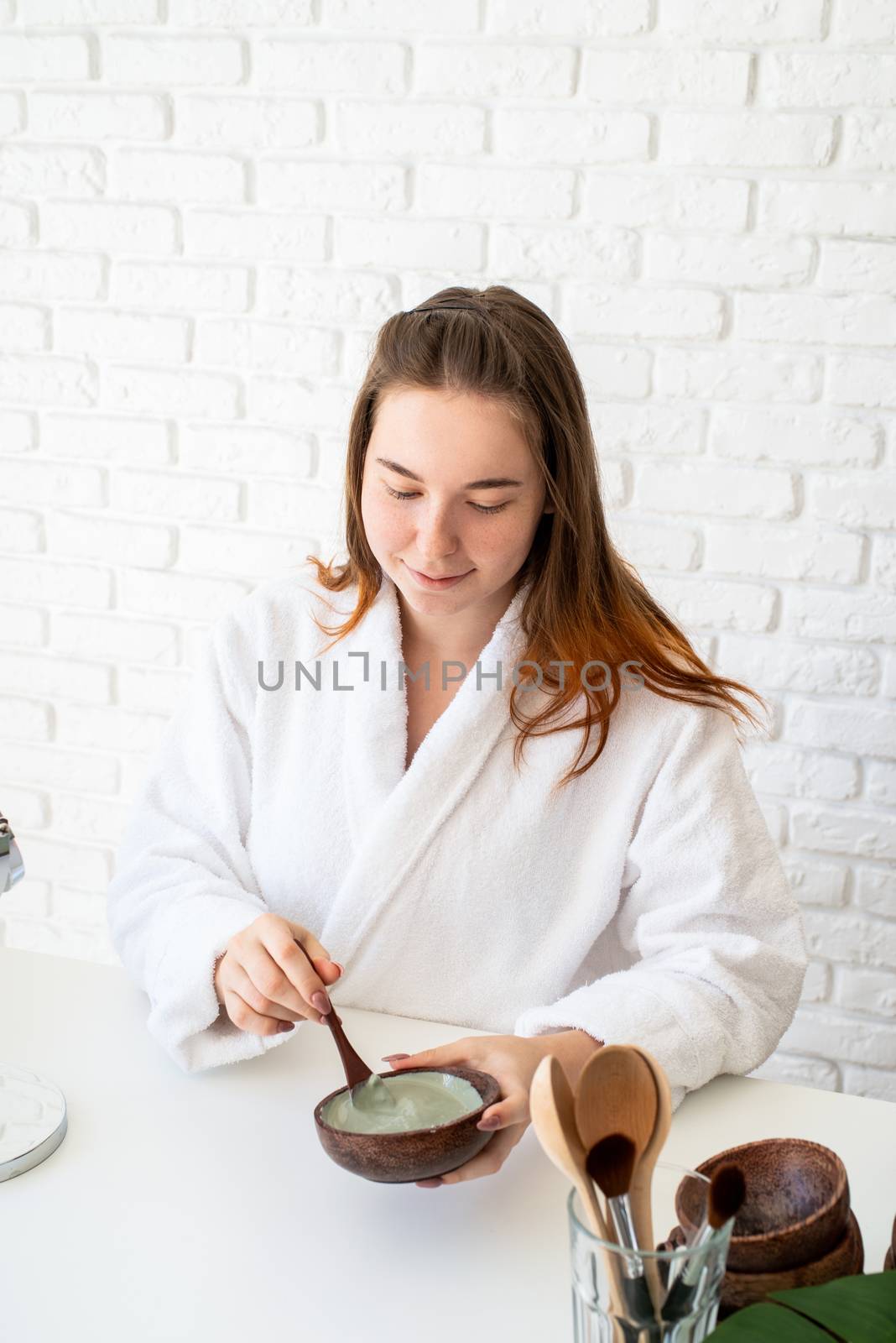 Spa and wellness. Natural cosmetics. Self care. Young caucasian woman wearing bathrobes doing spa procedures using natural cosmetics