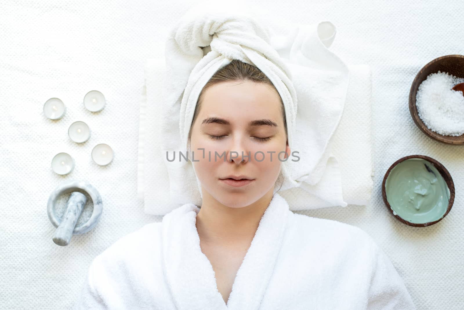 Top view of a relaxed woman with closed eyes having spa procedures using natural cosmetics by Desperada