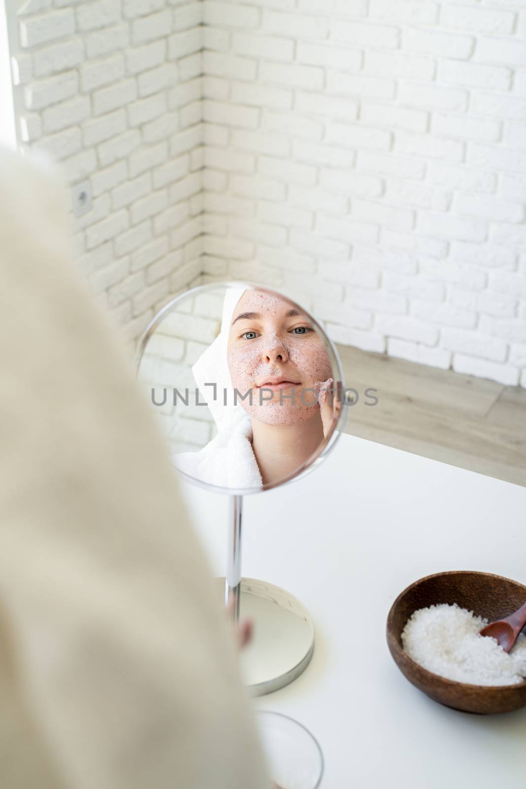 Spa and wellness. Natural cosmetics. Self care. Happy young woman applying face scrub on her face