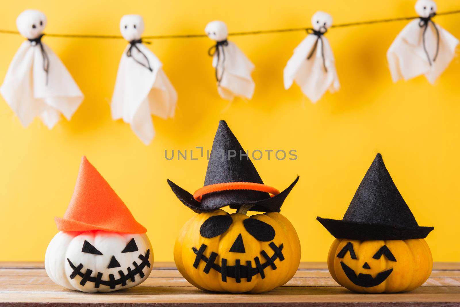Funny Halloween day decoration party, Baby cute white ghost crafts scary face hanging and halloween pumpkin head jack lantern smile and spider on wooden, studio shot isolated, Happy holiday concept