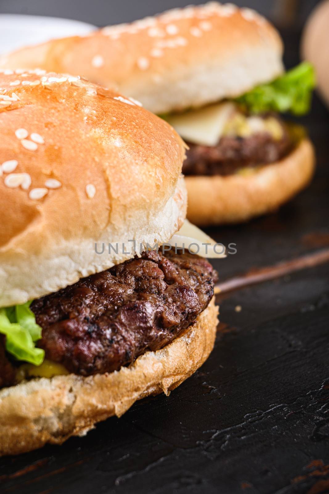 Homemade beef burgers on dark wooden background.