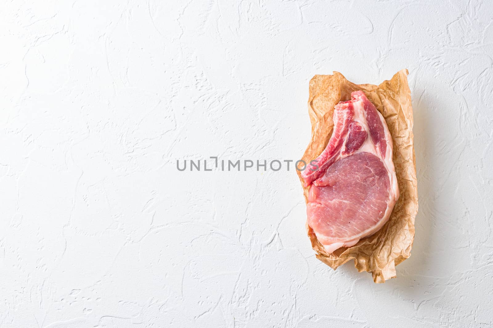 fresh bio raw meat organic cut pork on white stone table flatlay space for text.