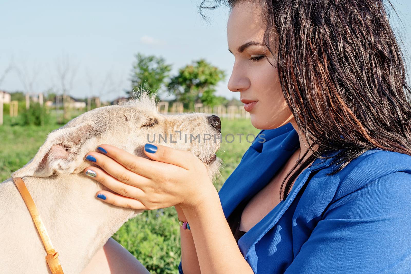 Pet care. Pet adoption. Young woman playing and hugging her dog in the park