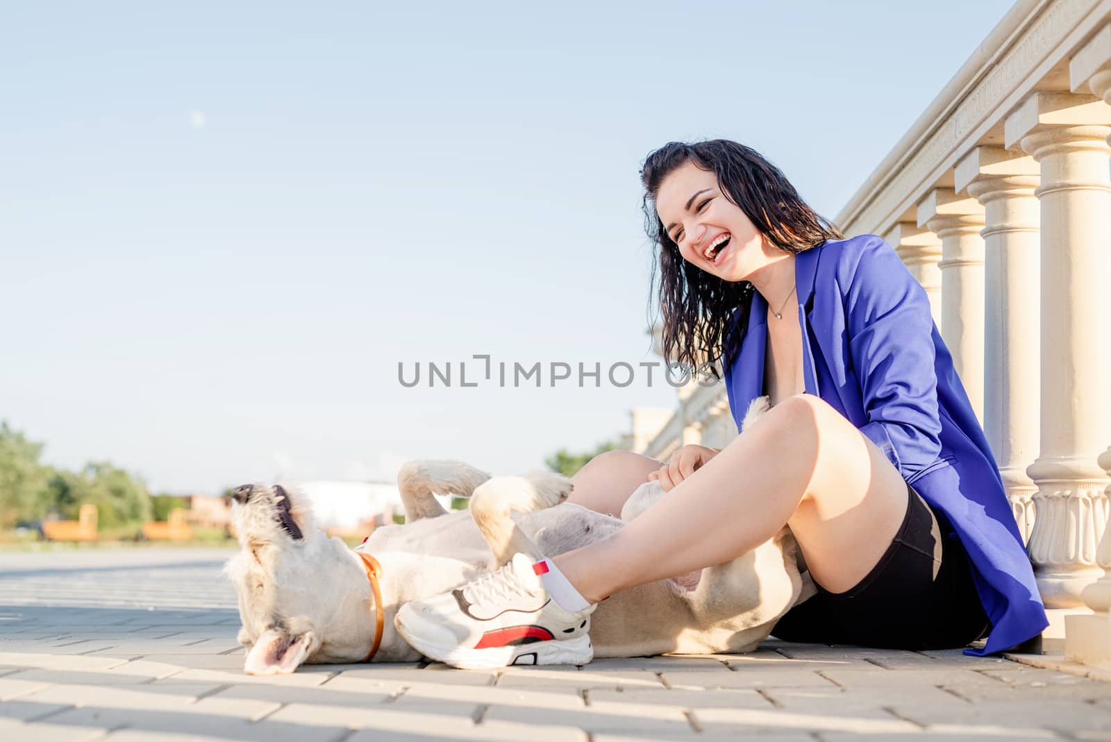 Pet care. Pet adoption. Young woman playing and hugging her dog in the park