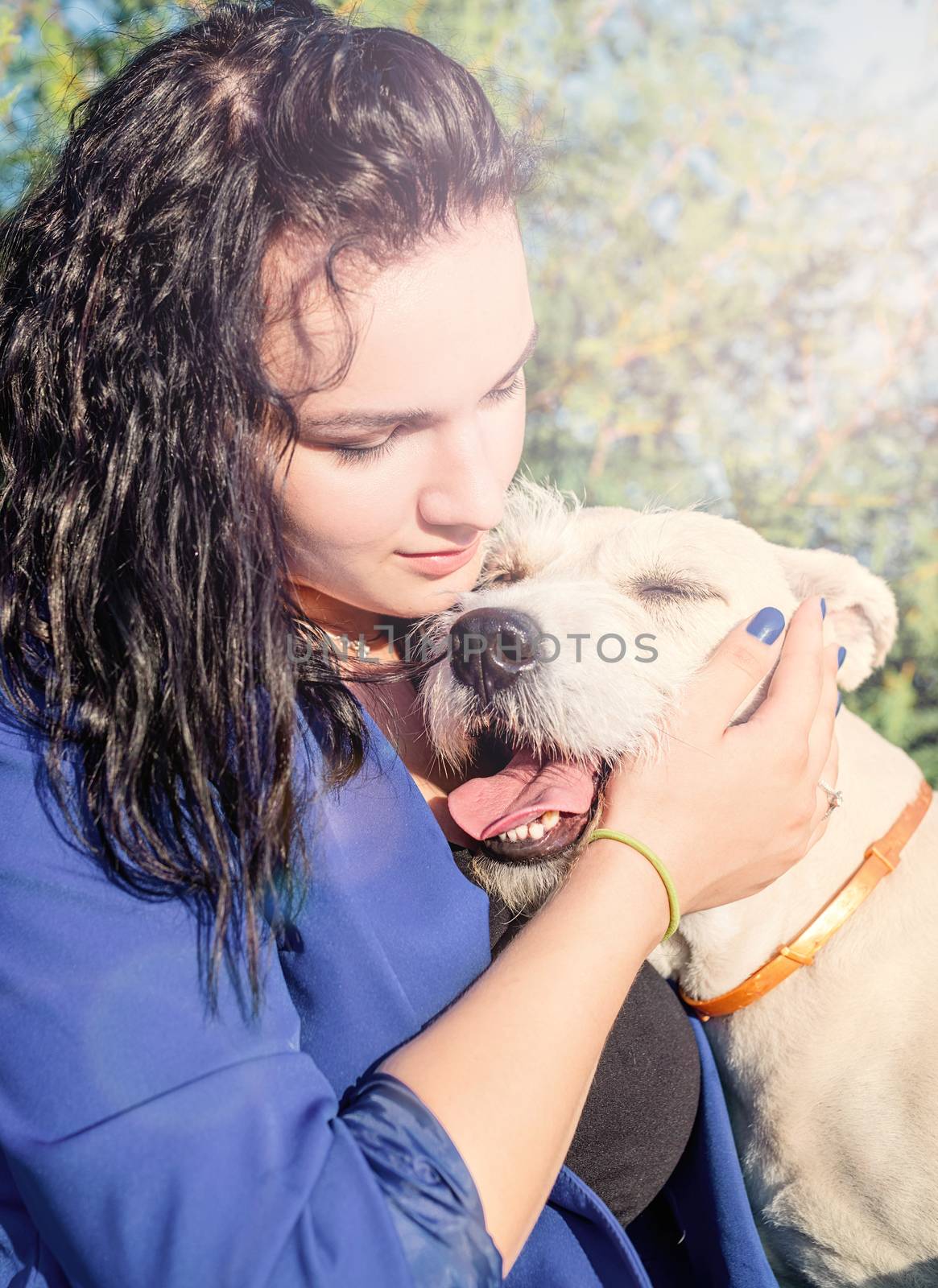 Pet care. Pet adoption. Young woman playing and hugging her dog in the park