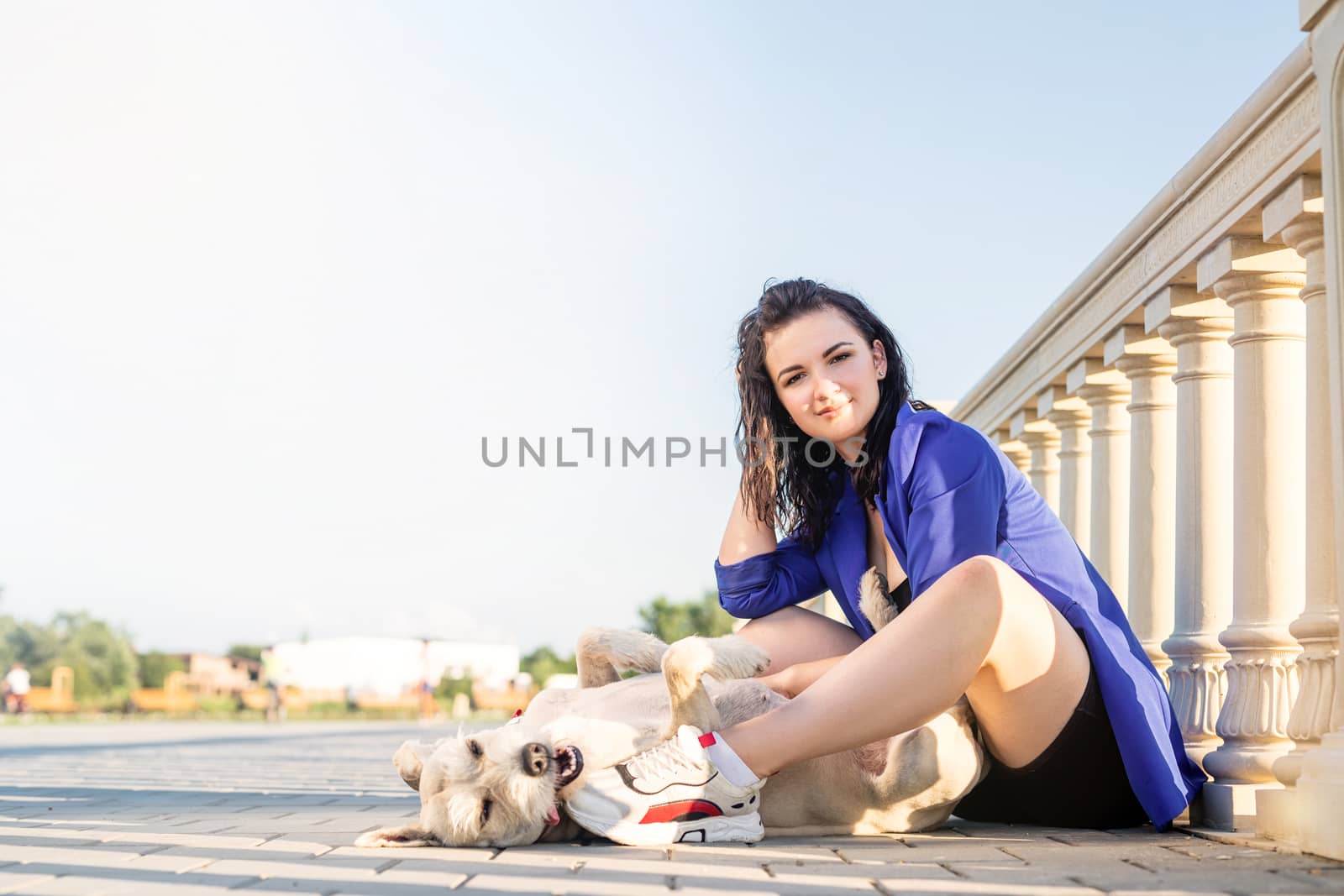 Pet care. Pet adoption. Young woman playing and hugging her dog in the park