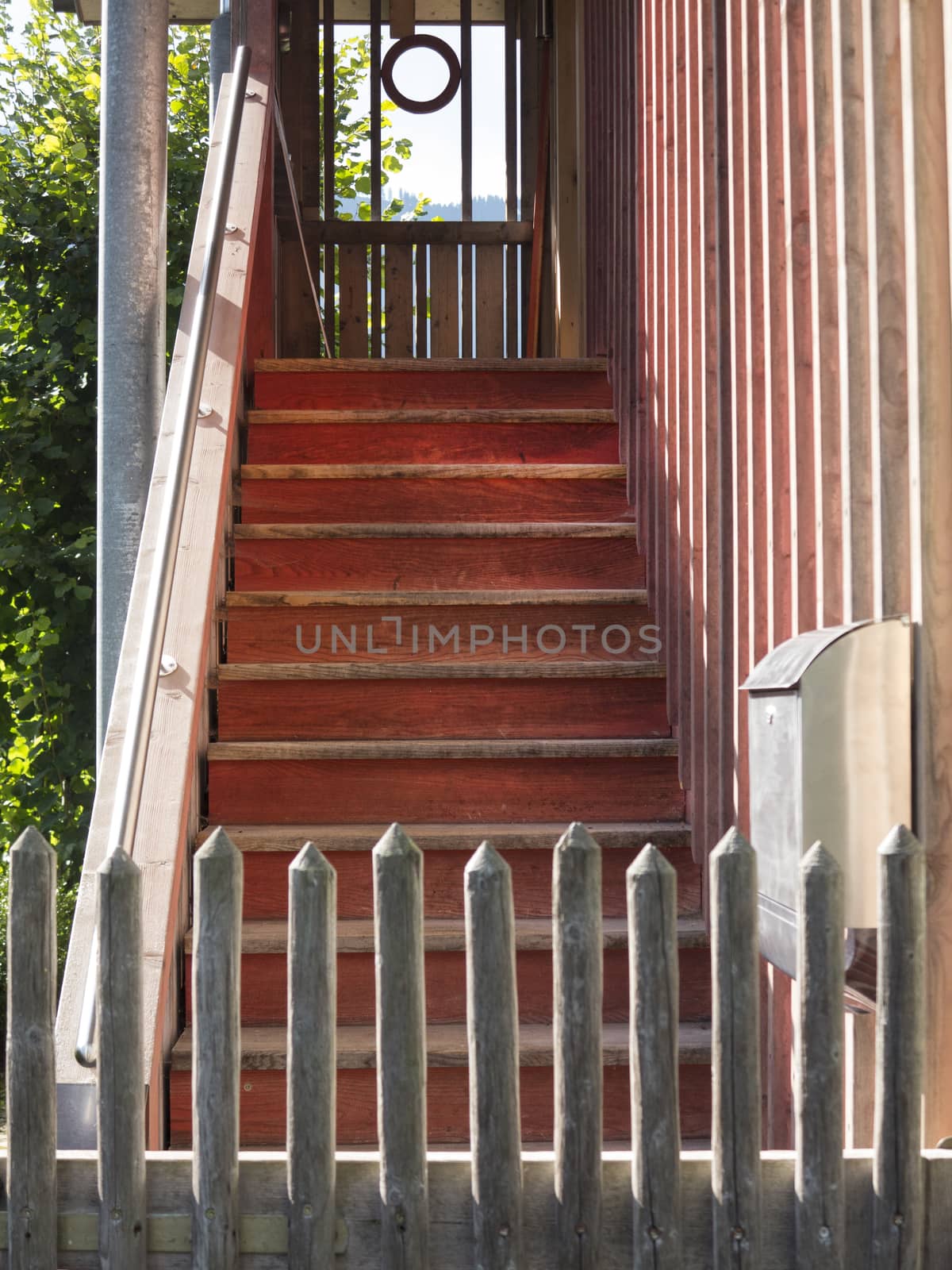 Old wooden stairway behind a fence leading upward