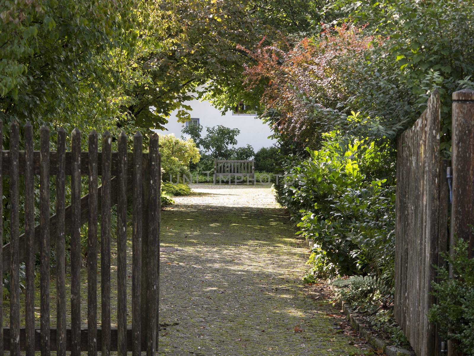 Open wooden gate and gravel driveway