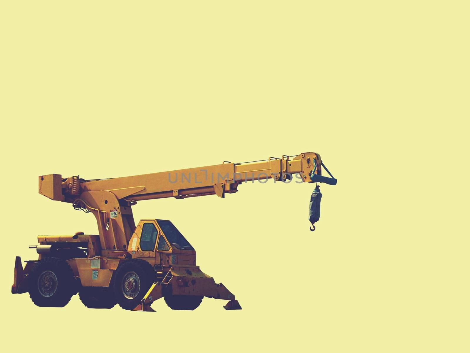 Construction backhoe with a pale yellow background.High quality photo