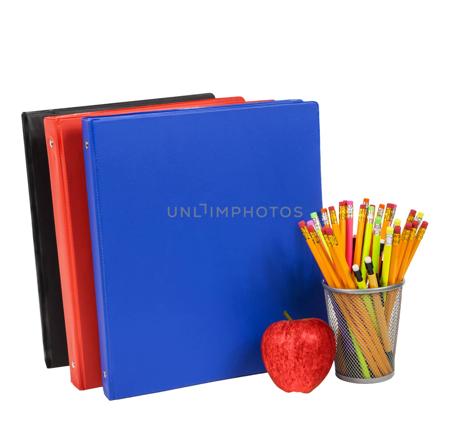 Horizontal shot of colorful notebooks, pencils and a red apple isolated on white background.