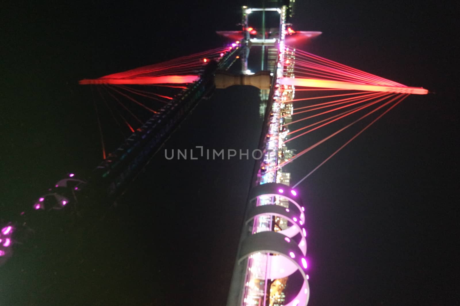 Night view of a beautiful scene of bridge over sea water in the evening time with colorful lights.