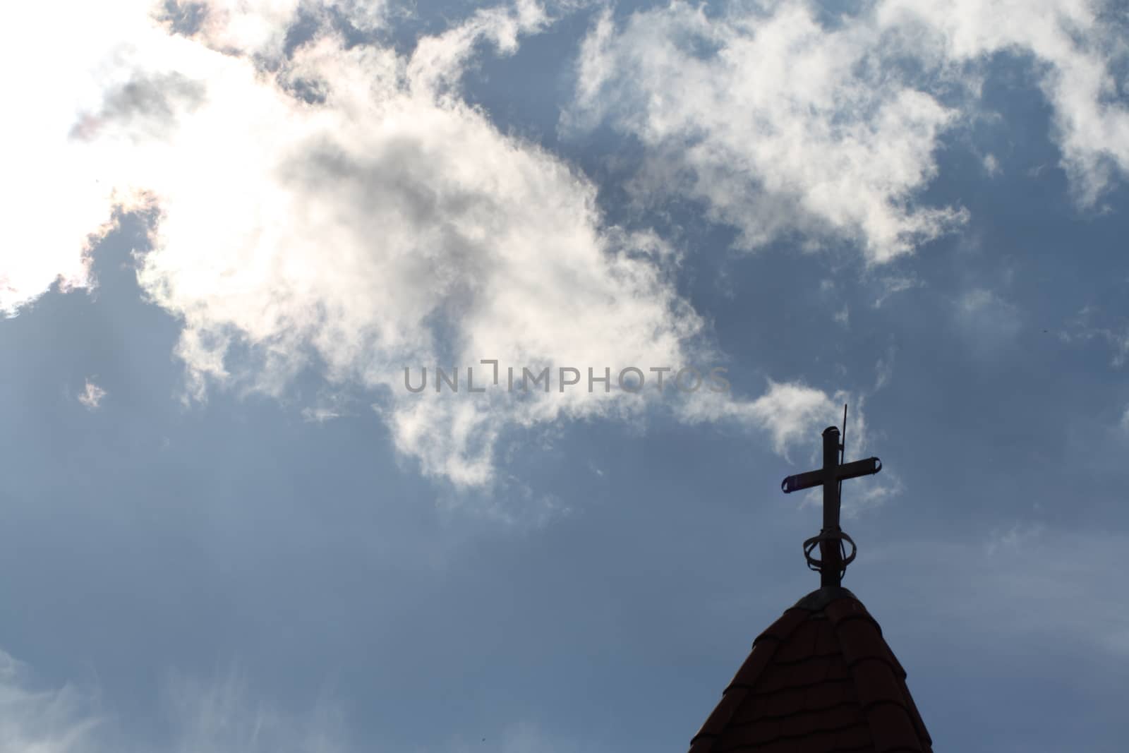 The cross at the top of the church and the beautiful blue sky . High quality photo